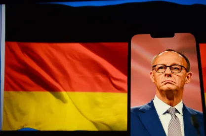 German Chancellor Friedrich Merz on a phone screen with German flag in the background